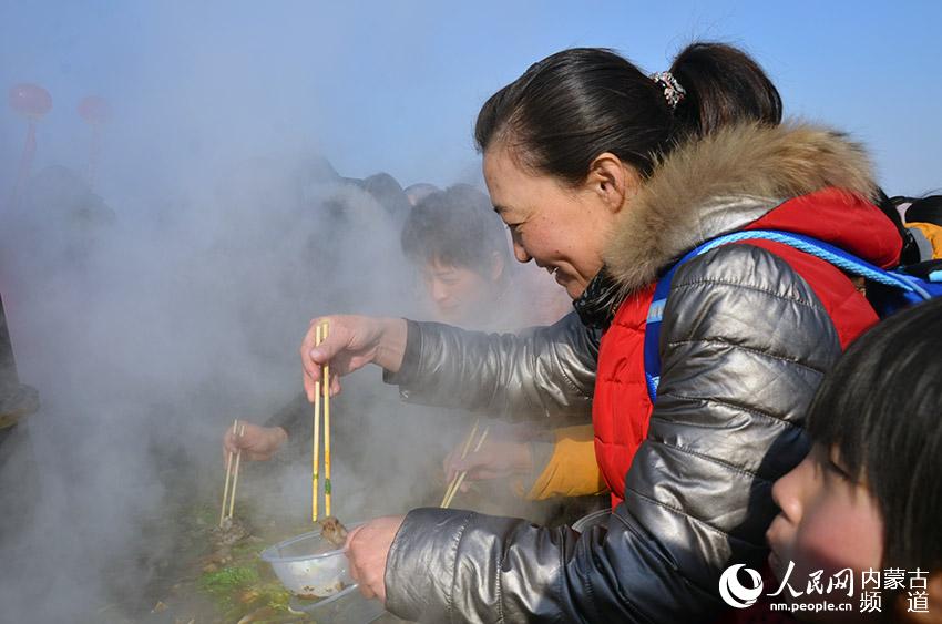 參加活動的市民圍著大火鍋品嘗美味肉和蔬菜。