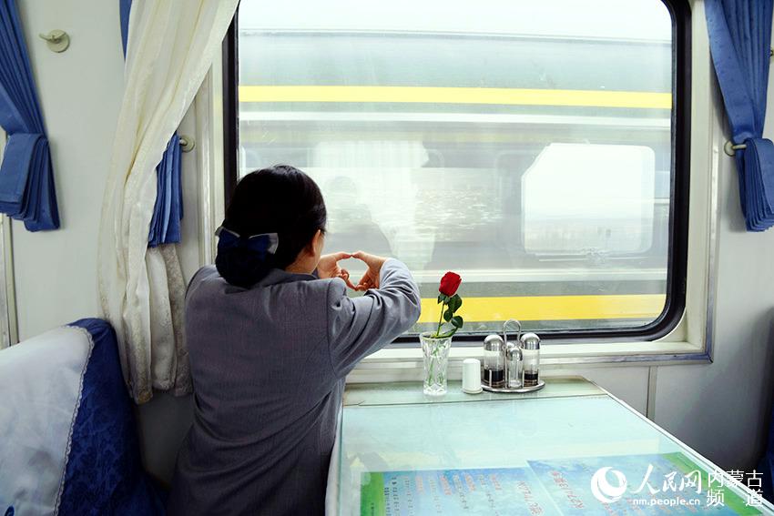 1月18日，兩輛列車在查干渾迪線路所“會車”，飛馳的列車上妻子依稀看到了丈夫的身影，也用手比出愛的手勢。趙欣 張偉 攝