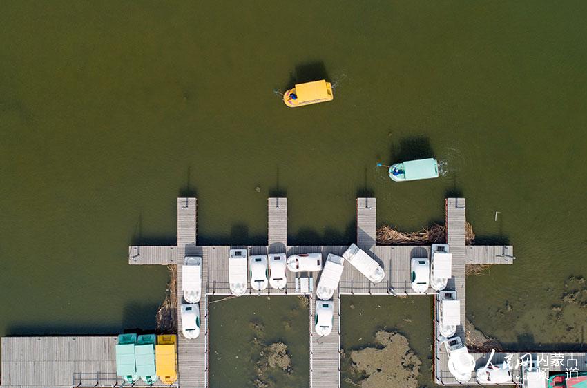 呼和浩特市濕地公園工作人員清理湖面雜物（無人機拍攝）。