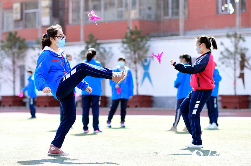 呼和浩特市第十八中学高三年级学生在体育课上踢毽球.