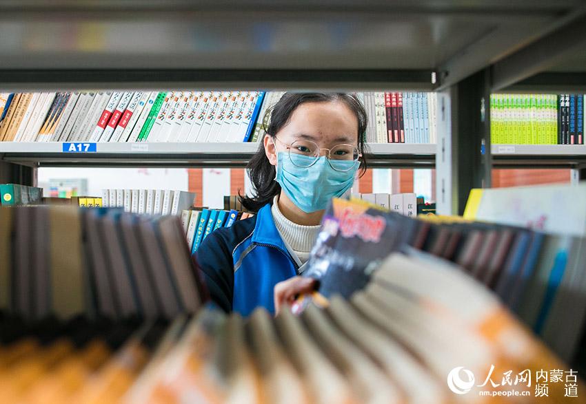呼和浩特市第二十六中學“小圖書管理員”在校圖書館整理圖書。
