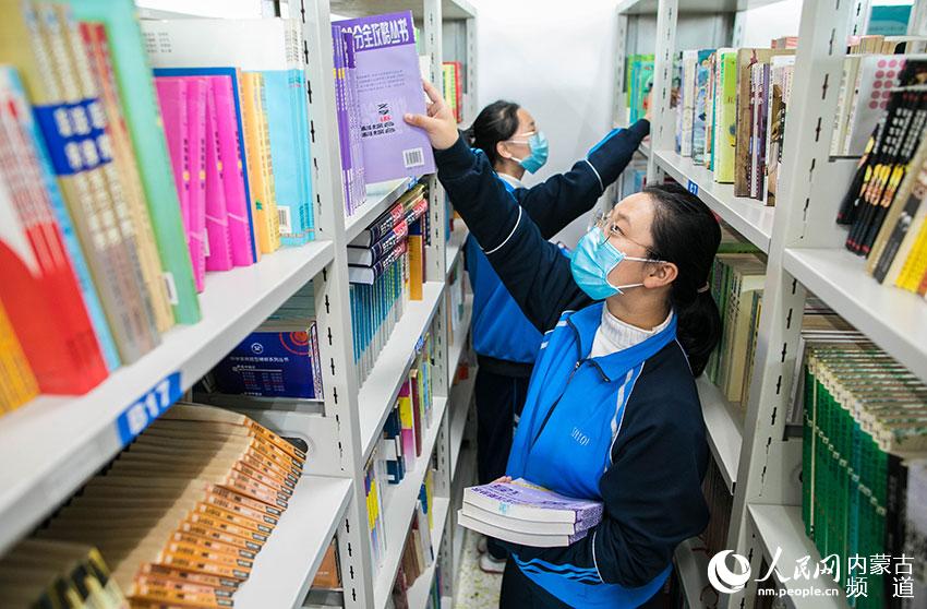 呼和浩特市第二十六中學“小圖書管理員”在校圖書館整理圖書。