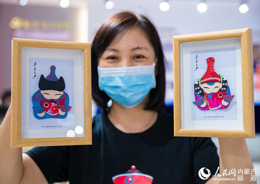 手工藝人在呼和浩特市玉泉區首屆女性手工藝品展上展示蒙古族布貼畫。