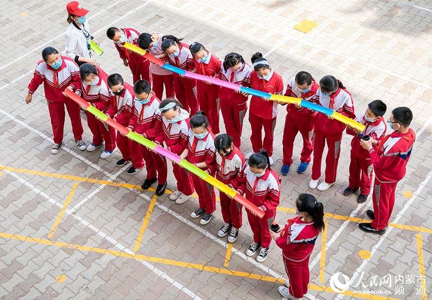 呼和浩特市玉泉區頭道巷小學學生在參加團體心理拓展項目“快樂傳送帶”比賽。