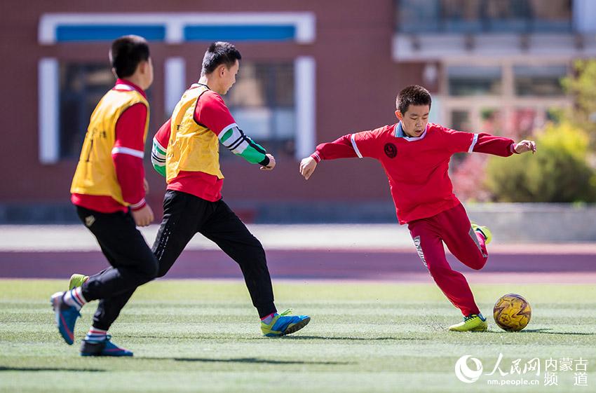 呼和浩特市玉泉區恆昌店巷小學學生在體育課上進行足球分組對抗練習。