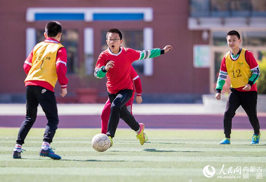 呼和浩特市玉泉區恆昌店巷小學學生在體育課上進行足球分組對抗練習。