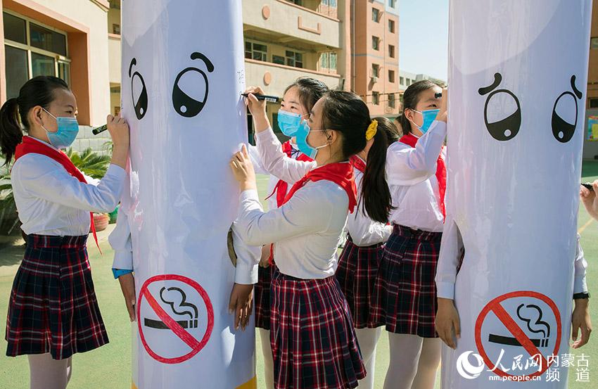 5月28日，內蒙古自治區呼和浩特市玉泉區恆昌店巷小學學生在自制的巨型“香煙”上簽名。