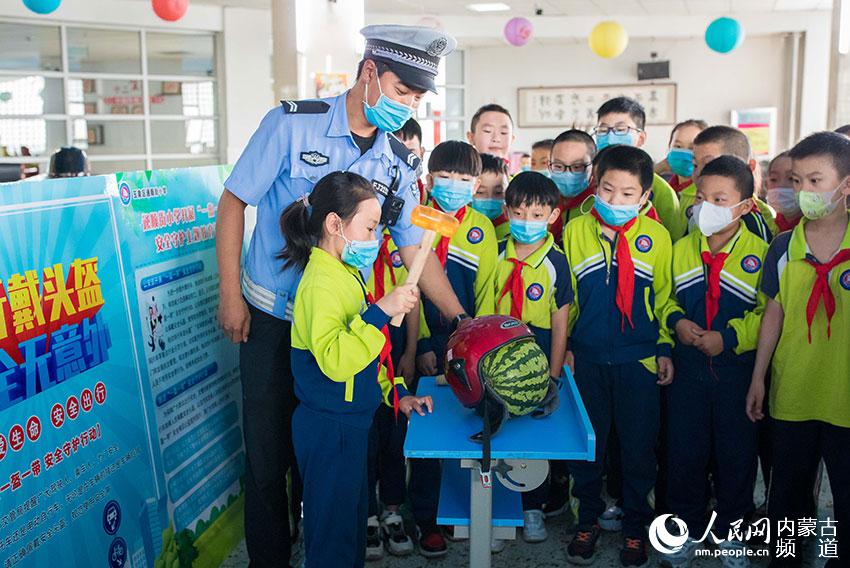 內蒙古呼和浩特市玉泉區通順街小學學生通過趣味模擬實驗，認識佩戴安全頭盔的重要性。