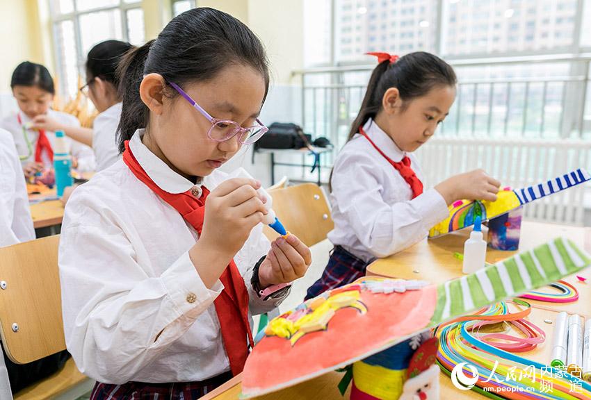 內蒙古自治區呼和浩特市玉泉區恆昌店巷小學學生在繪制創意馬勺臉譜。