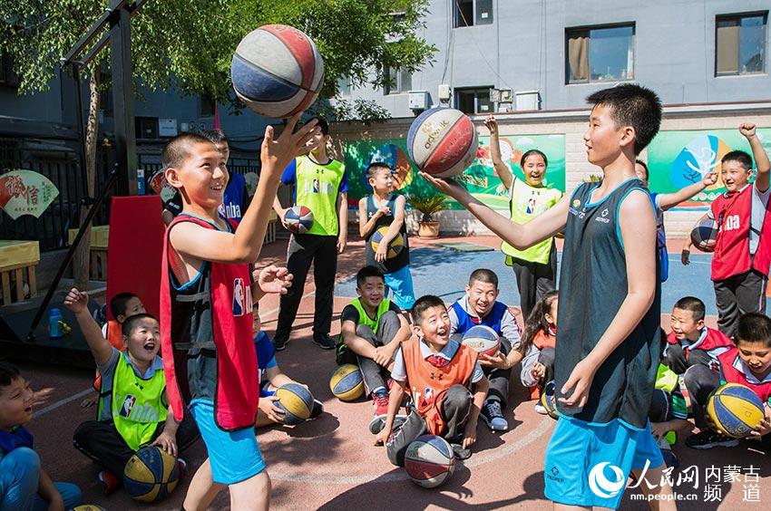 內蒙古呼和浩特市玉泉區石頭巷小學學生在戶外籃球特色體育課上練習花式籃球。