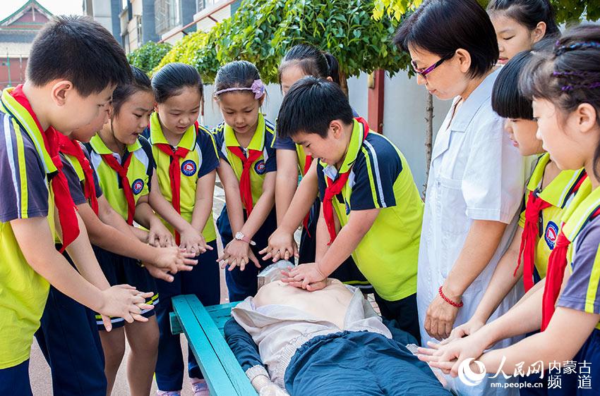 內蒙古呼和浩特市玉泉區通順街小學學生在校醫的指導下學習心肺復蘇急救技能。