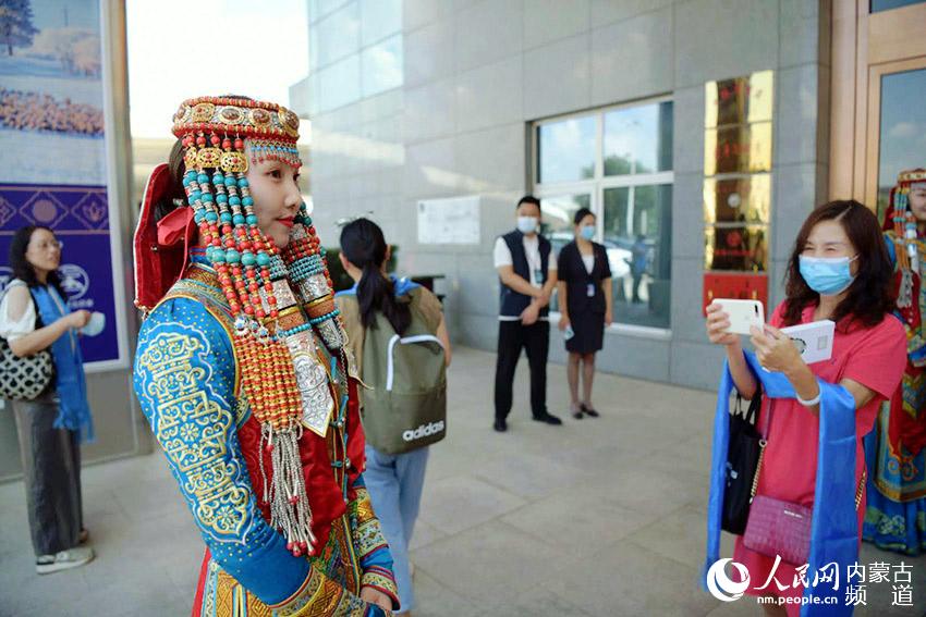游客在机场纷纷举起手机拍摄蒙古族服饰。陈立庚 摄