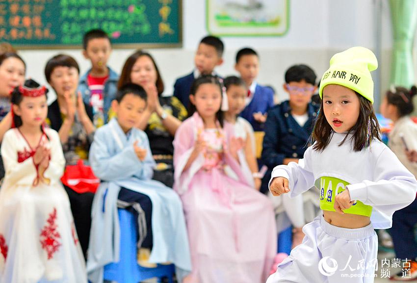 呼和浩特市賽罕區敕勒川綠地小學學生在校園燈會主題班隊會上表演舞蹈。