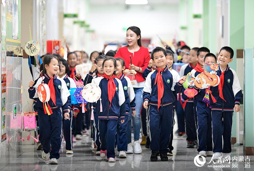 呼和浩特市賽罕區敕勒川綠地小學教師和學生手持花燈參加校園燈會。