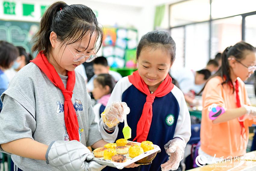 呼和浩特市賽罕區敕勒川綠地小學學生在校園燈會上制做月餅。