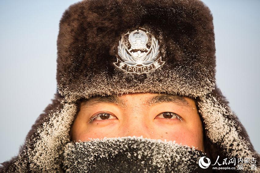 二連出入境邊防檢查站民警在崗位上迎接新年第一縷陽光，民警帽子和防寒面罩上挂滿冰霜。