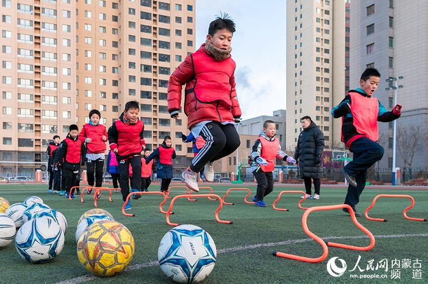 呼和浩特市玉泉區恆昌店巷小學小球員在球場上進行足球體能訓練。