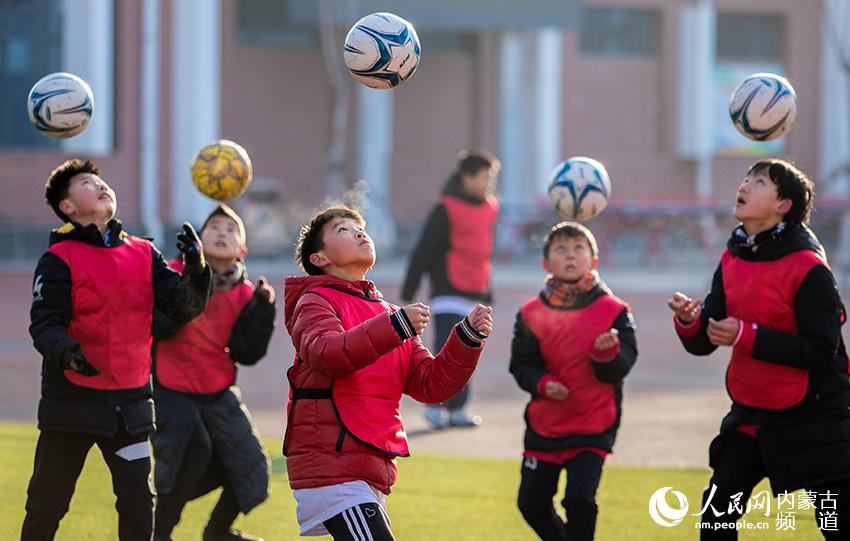 呼和浩特市玉泉區恆昌店巷小學小球員在足球場上進行頭球訓練。