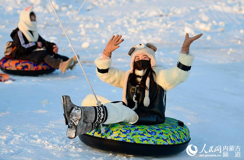 游客在位於呼倫貝爾市海拉爾區的兩河聖山旅游文化景區體驗旋轉雪圈游戲。