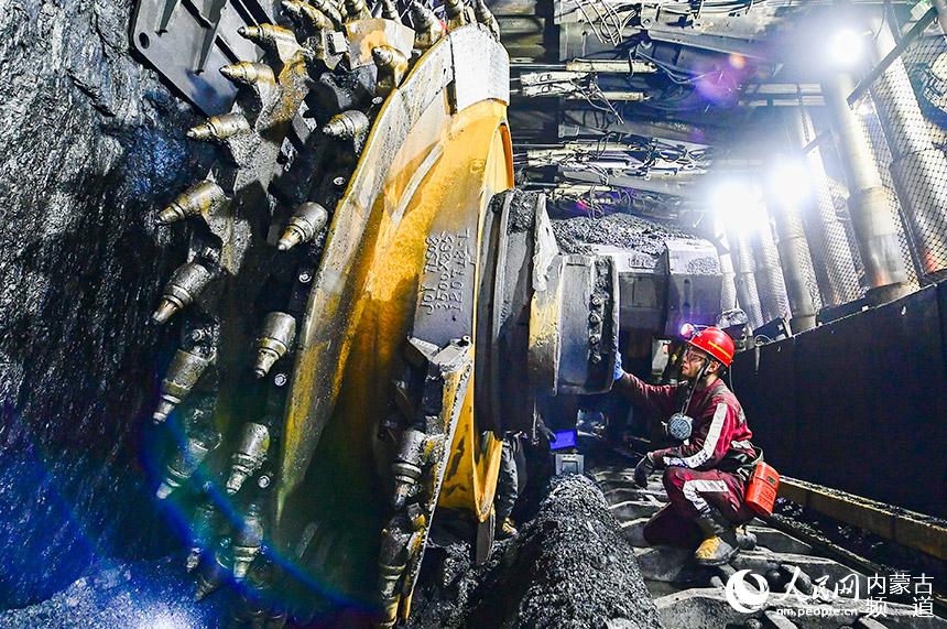 工人在伊金霍洛旗一家煤礦礦井裡檢修採煤機。王正攝