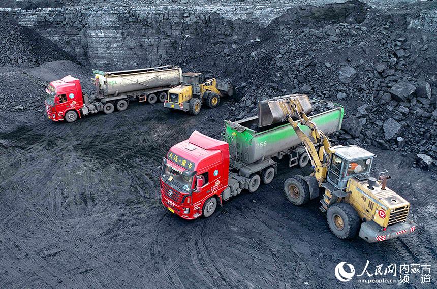 裝載機在伊金霍洛旗一家露天煤礦為運輸車輛裝煤。王正攝