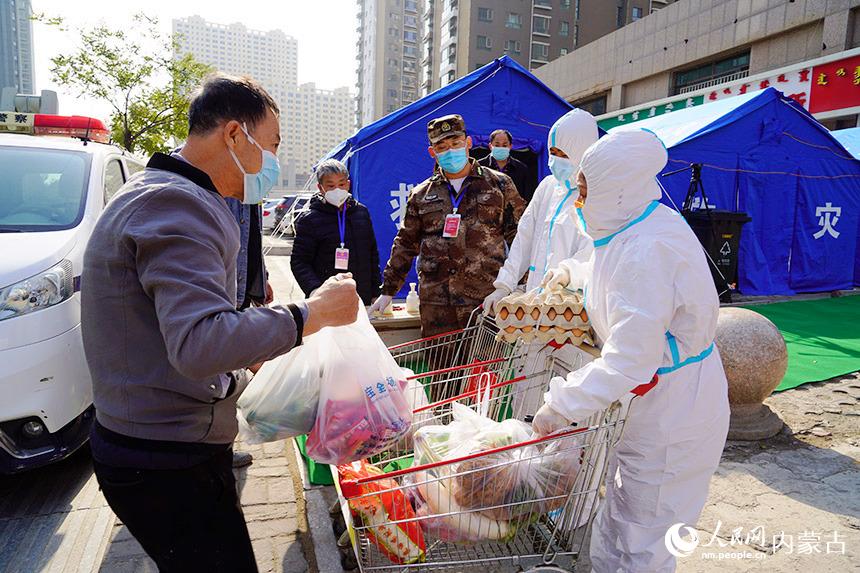 呼和浩特市新城区社区工作人员给华侨新村居民送生活所需用品。新城区委宣传部供图