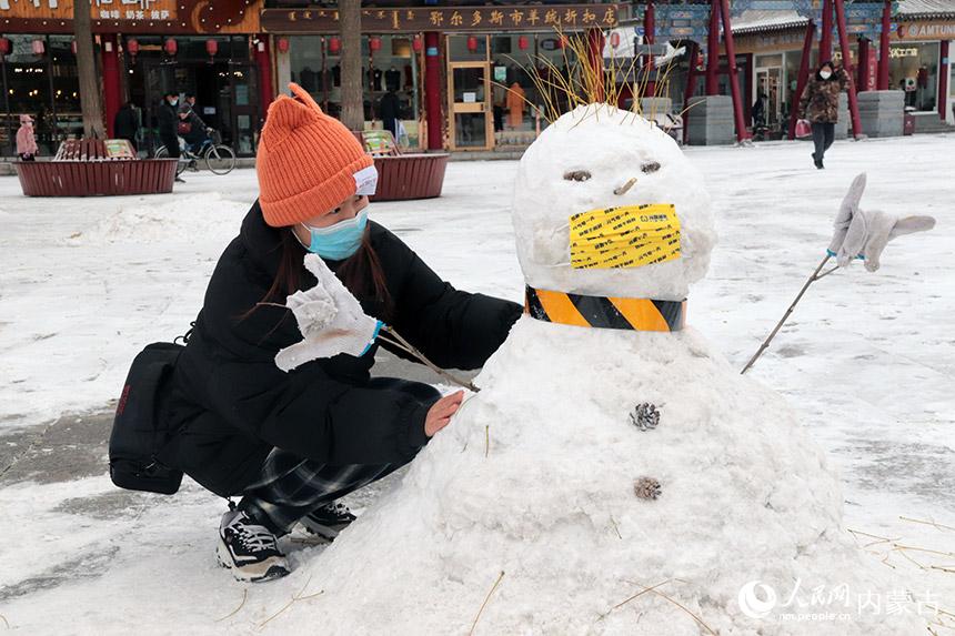 市民在大召廣場上堆雪人。人民網 劉藝琳攝