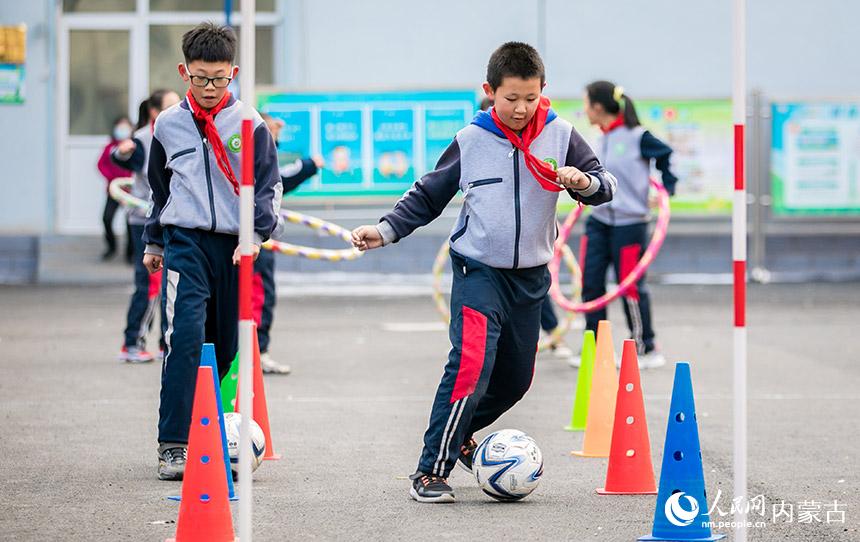 呼和浩特市玉泉區公義店小學的學生在大課間進行趣味足球游戲。丁根厚攝