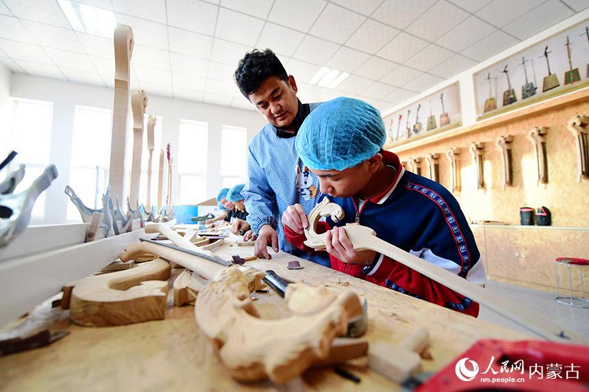 胡雅格正在指導學生制作馬頭琴琴頭。人民網 寇雅楠攝