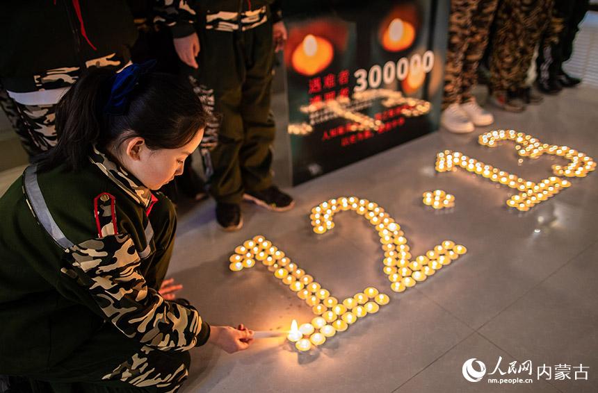 呼和浩特市玉泉区五塔寺东街小学少先队员参加南京大屠杀死难者国家公祭日“烛光祭”。丁根厚摄