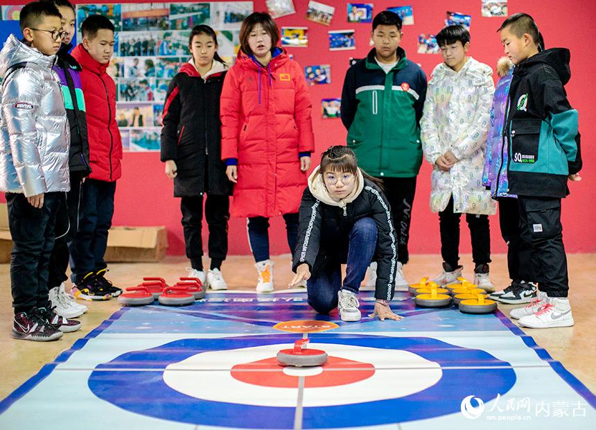 12月22日，內蒙古呼和浩特市玉泉區恆昌店巷小學學生在體驗陸地冰壺。丁根厚攝