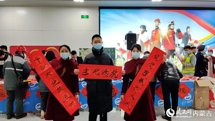 乘客和地铁工作人员一起展示乘客写的春联。张晓宇摄
