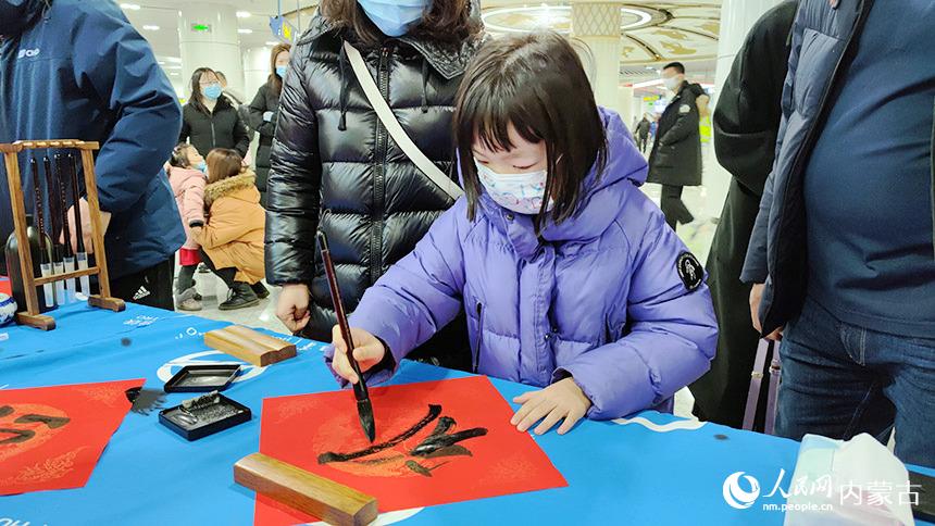 小朋友在亲自为家人写福字送祝福。张晓宇摄