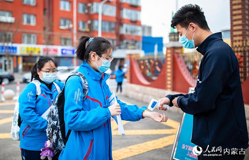 內蒙古自治區呼和浩特市第六中學高三年級學生入校前接受體溫檢測。丁根厚攝