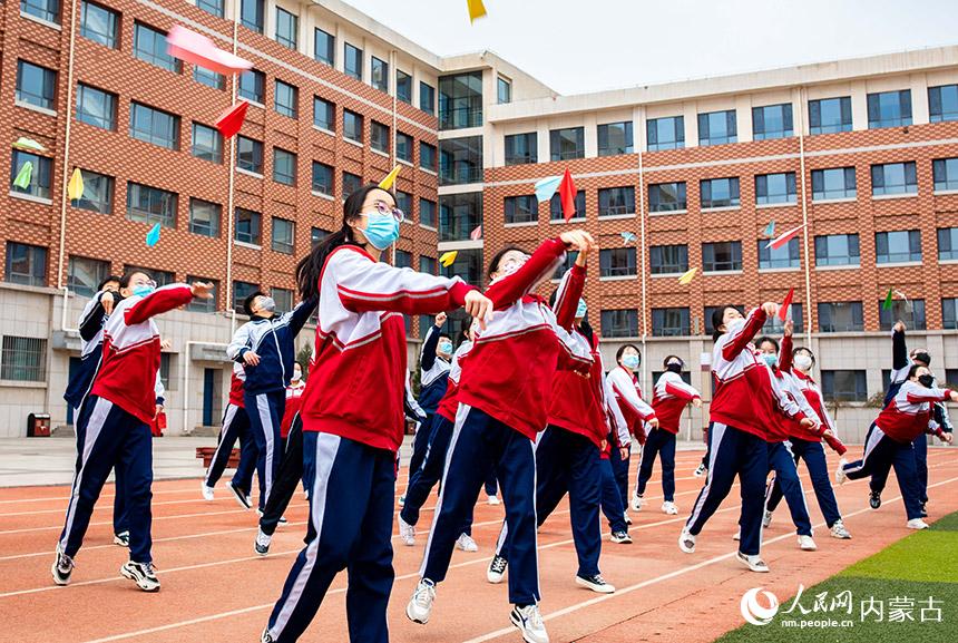 內蒙古自治區呼和浩特市第六中學高三年級學生將寫有自己夢想的紙飛機擲向天空。丁根厚攝