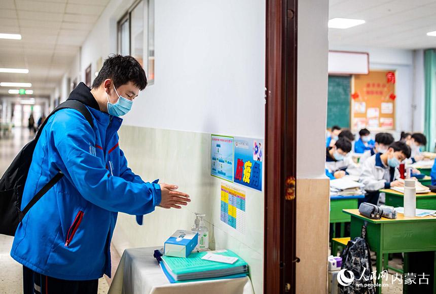 內蒙古自治區呼和浩特市第六中學高三年級學生在班級防疫角清潔手部。丁根厚攝