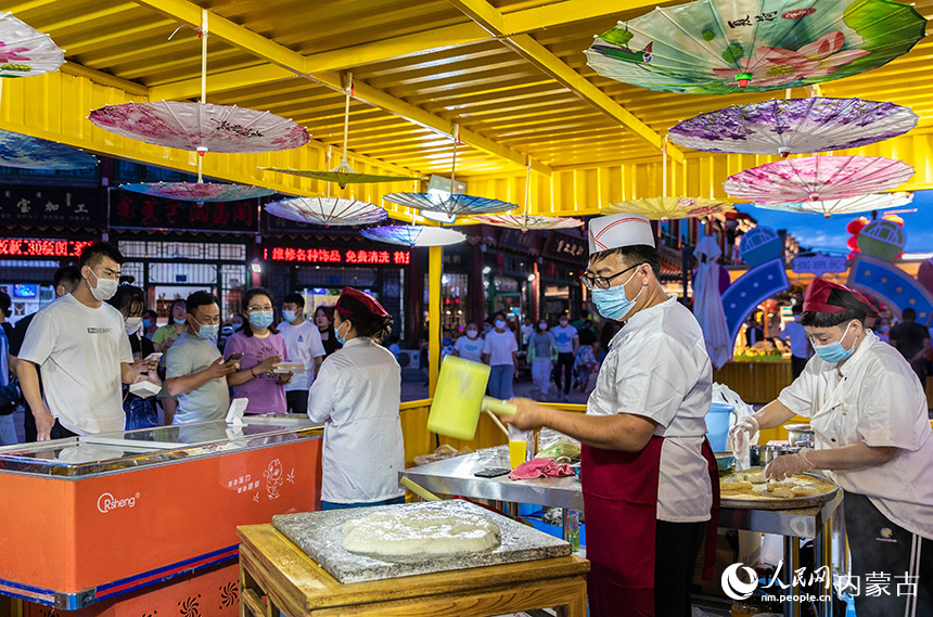 工作人員在呼和浩特市玉泉區塞上老街一家快閃店制作特色小吃打糕。丁根厚攝