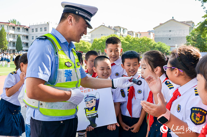 呼和浩特市玉泉区五塔寺东街小学学生在暑期安全教育活动中体验酒精测试仪。丁根厚摄