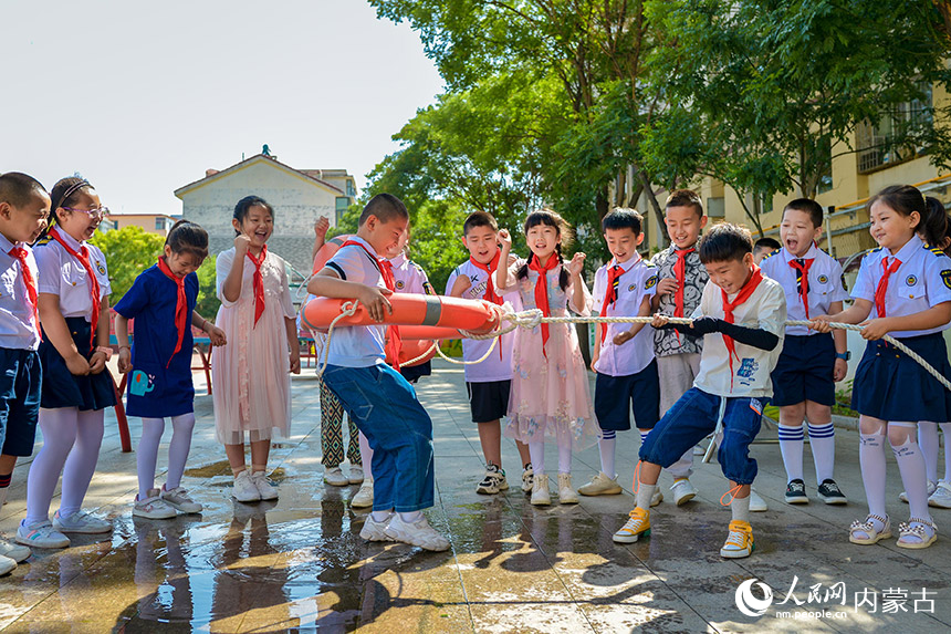 呼和浩特市玉泉区五塔寺东街小学学生在暑期安全教育活动中学习如何用救生圈救人。丁根厚摄