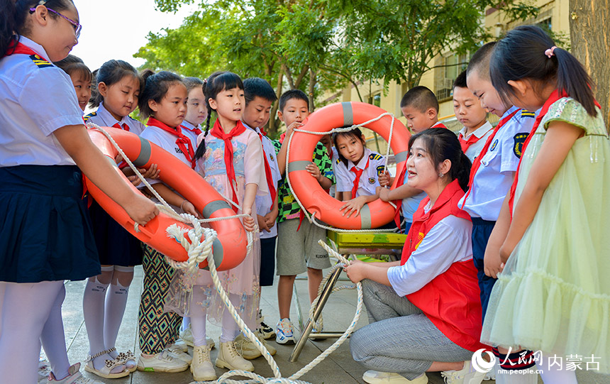 呼和浩特市玉泉区五塔寺东街小学学生在暑期安全教育活动中学习救生圈使用方法。丁根厚摄