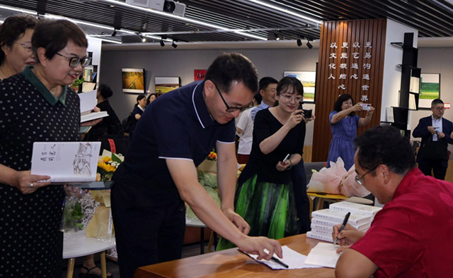 高雲峰（右）在為讀者簽名贈書。新華社記者 賈立君 攝
