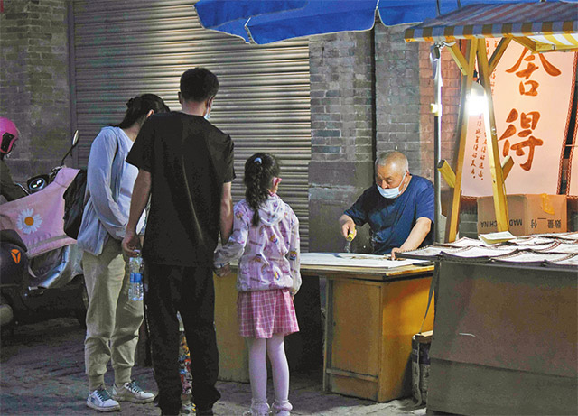 游客在呼和浩特市塞上老街欣赏非遗毛毡烙画技艺。见习记者 杨林枝 摄