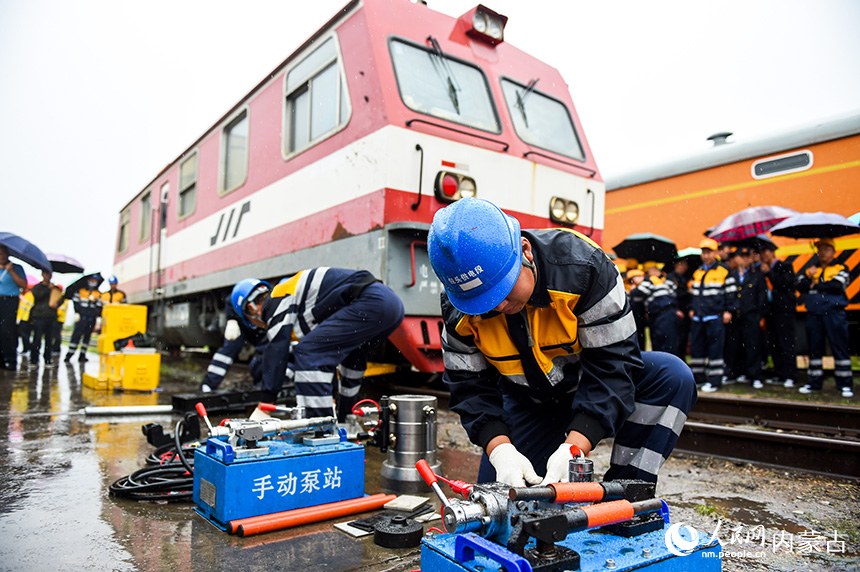 铁路职工对货物列车脱轨进行模拟救援演练。唐哲摄