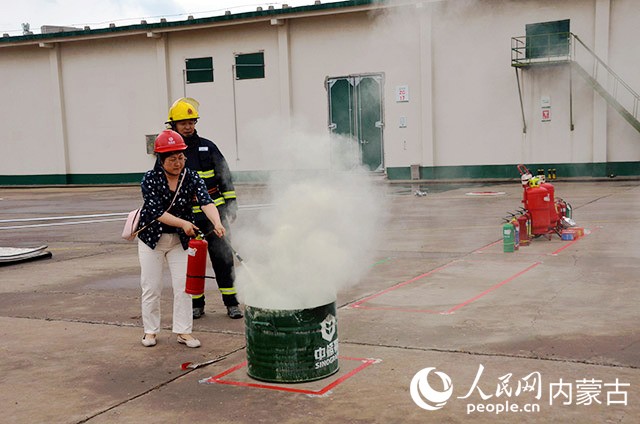 参观人员正在使用灭火器模拟灭火。实习生姚颖超摄