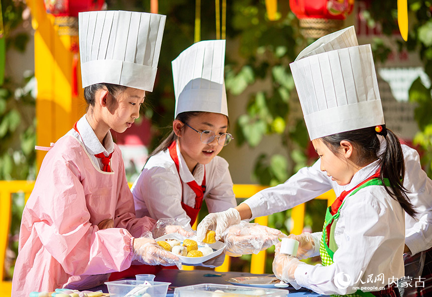 内蒙古呼和浩特市玉泉区恒昌店巷小学学生在学习做月饼。丁根厚摄