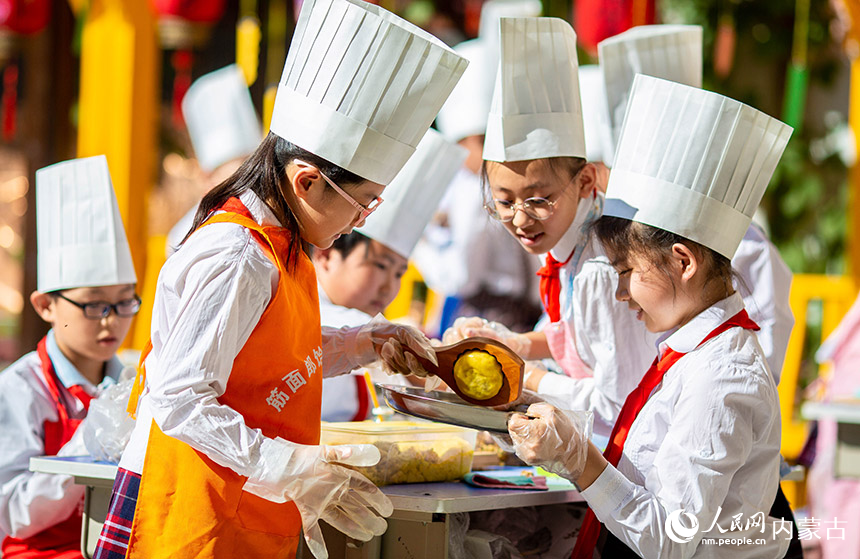 内蒙古呼和浩特市玉泉区恒昌店巷小学学生在学习做月饼。丁根厚摄