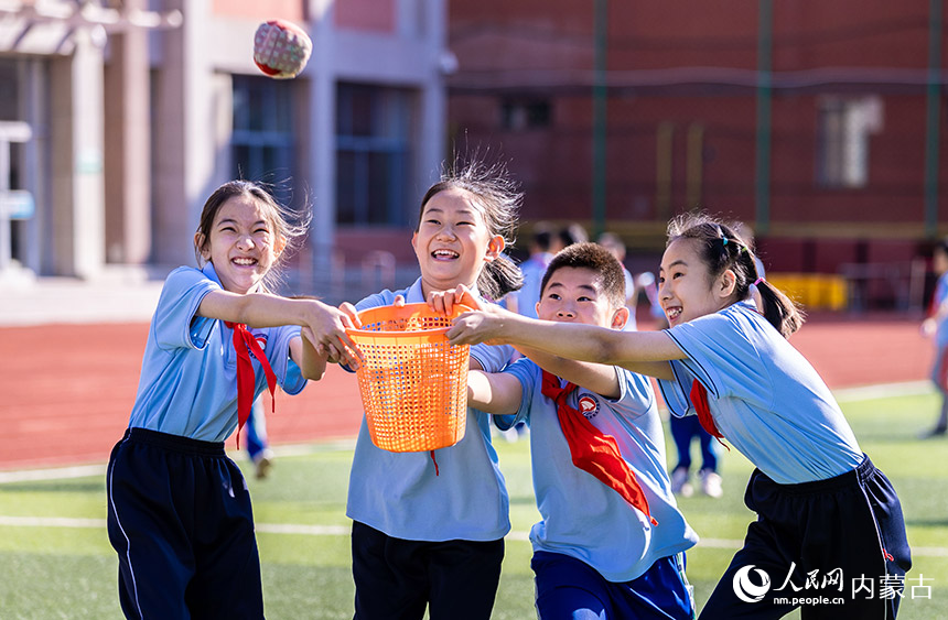 呼和浩特市玉泉区通顺街小学学生课后在操场上玩接沙包游戏。丁根厚摄