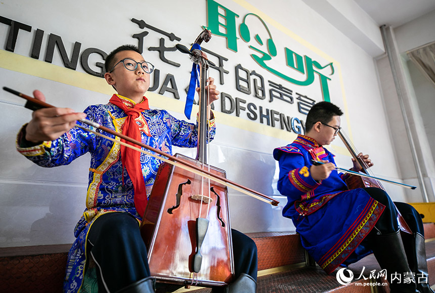 呼和浩特市玉泉区通顺街小学学生课后在活动室学习马头琴演奏。丁根厚摄