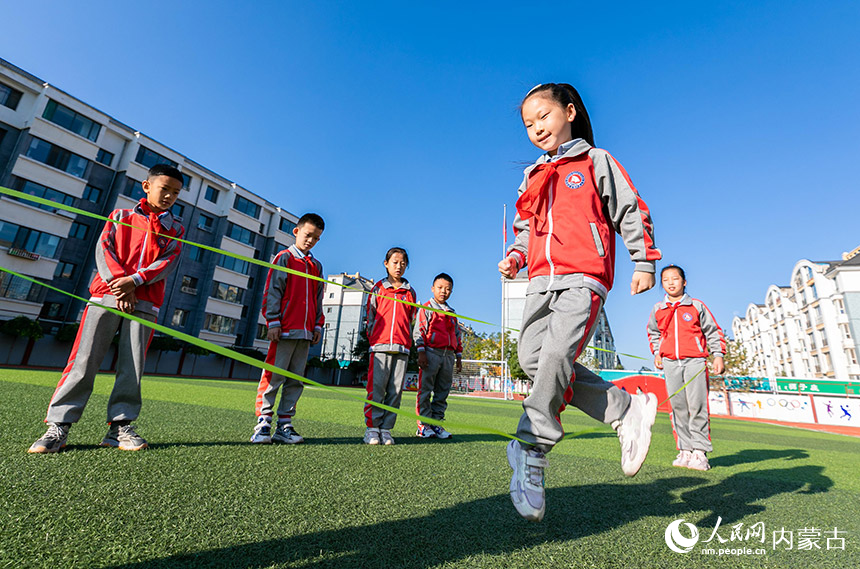 呼和浩特市玉泉区通顺街小学学生课后在操场上玩跳皮筋。丁根厚摄