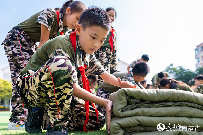 呼和浩特市玉泉区五塔寺东街小学少年军校学生在体验叠军被。丁根厚摄
